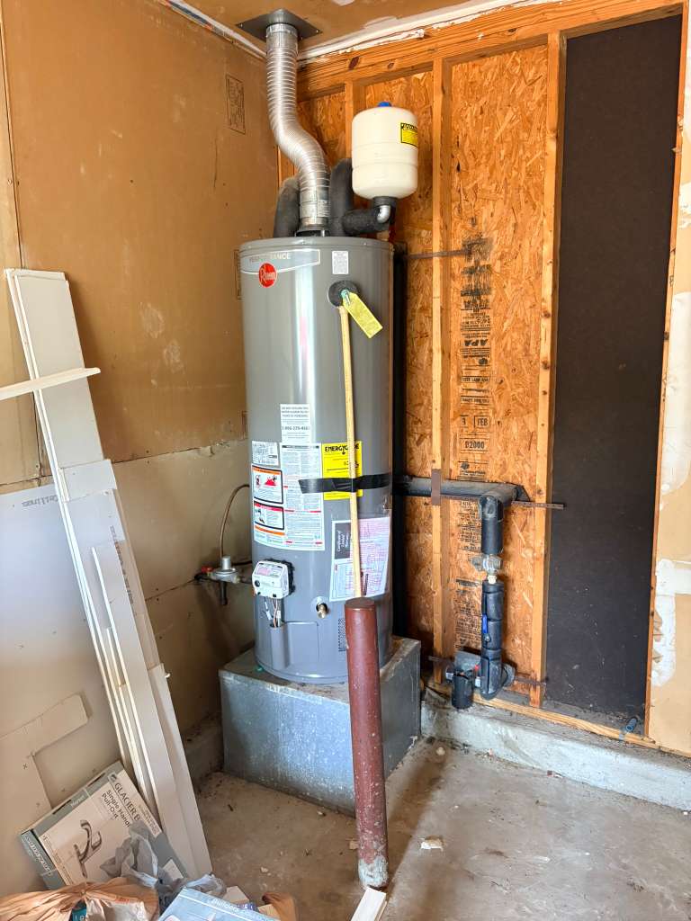 Rheem tank water heater installed in garage with expansion tank